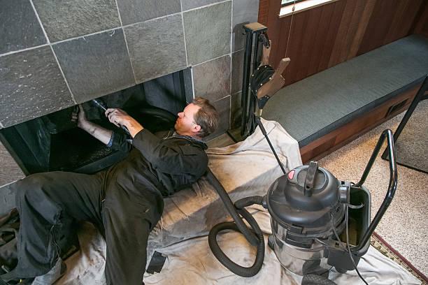 Chimney Sweep cleaning fireplace inside of home